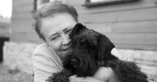Pet Ownership and Effect on Mental Health in Seniors. Black & White picture of an elderly caucasian female hugging a little black dog.